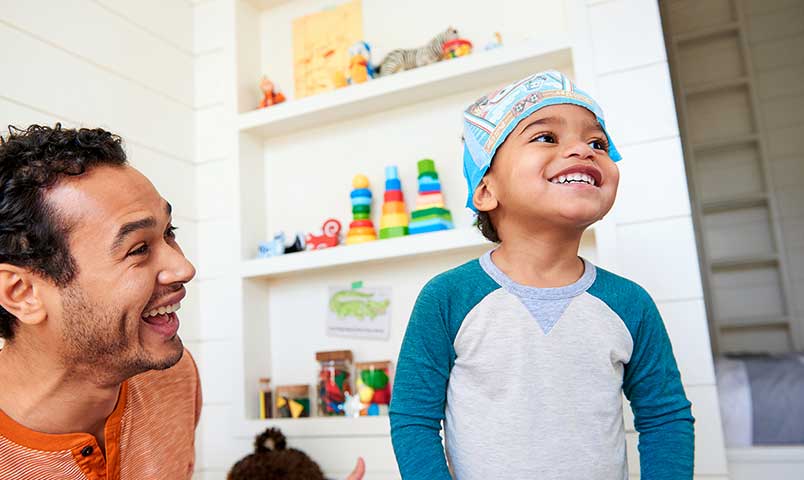 Little boy with diaper on his head having a grand old time