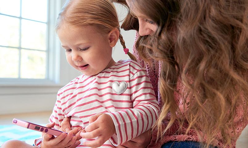 Madre e hija jugando con el teléfono