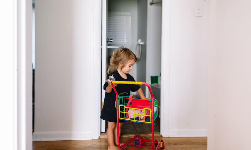 Enfant avec un petit caddie au milieu d'un couloir